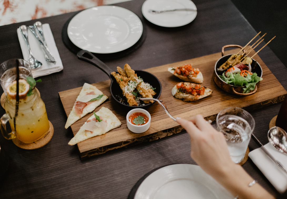 Crop woman eating delicious diverse meal in restaurant